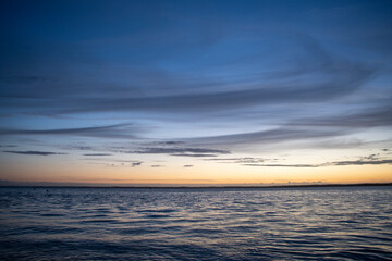 clear skies and calm seas as the sun sets over the Solent in summer time