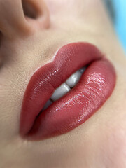 permanent makeup on the lips of a young woman of a delicate peach shade close-up