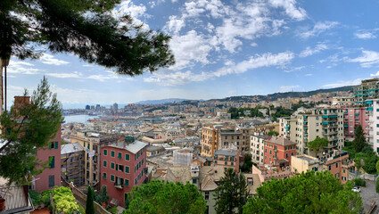 Fototapeta na wymiar Panoramic view of Genoa in Liguria, Italy with pastel coloured houses and port in background