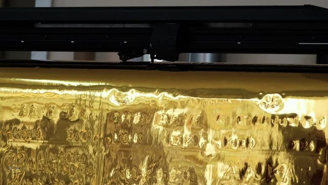Golden foil cutting plotter machine. Vinyl cutter plotter machine and moving cutting head.	
