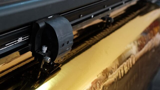 Golden foil cutting plotter machine. Vinyl cutter plotter machine and moving cutting head.	