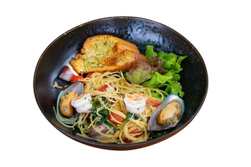 Stir-fried Spicy Spaghetti Seafood (Spaghetti Pad Kee Mao) Thai food style. Served in black tiled plate placed. Decorate with crispy bread vegetable Salad with mussels and shrimp