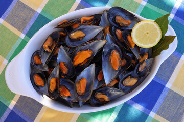 Portion of cooked mussels from the Galician estuary garnished with lemon and with natural light