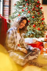 Young woman with credit card, gifts, and laptop. Online shopping at Christmas holidays. 