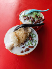 Malaysia traditional iced sweet dessert Cendol served in a bowl with glutinous rice, coconut milk and red beans.