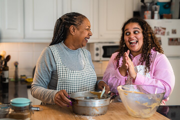 Happy African mother and daughter preparing a homemade dessert