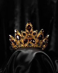 A hair ornament, a crown with a red stone, a symbol of power and beauty, on a black background © mira_y