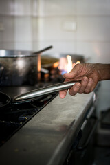 Elderly man cooking. Tano taking a pot. Hand of an old man working

