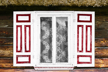 Fototapeta premium Wooden rustic window in small cottage house. Vintage red paint wall. Transparent glass window. Decorative white shutter. Wooden window background. Cottage house. Thatch roof vintage cabin wall.