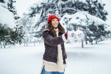 Fototapeta na wymiar Happy woman enjoying first snow in the forest. Holidays, rest, travel concept