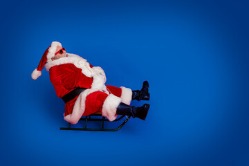 Full size profile photo of funny santa go by sled wear cap glasses coat pants shoes isolated on red...