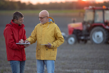 Fototapeta premium Farmers shaking hands in field in autumn