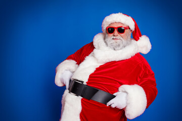 Photo of funny fat santa claus wear red headwear hat dark glasses smiling empty space celebrating noel isolated red color background