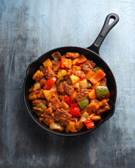 Sweet and Sour Pork with bell pepper, pineapple in iron cast pan