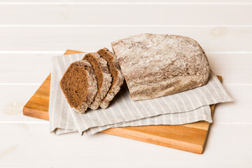 Assortment of freshly sliced baked bread with napkin on rustic table top view. Healthy unleavened bread. French bread slice