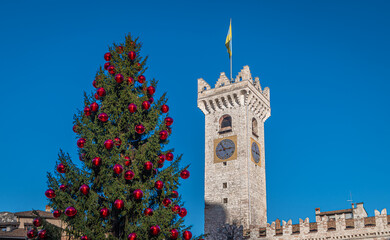 Fototapeta premium Trento Christmas, Cathedral bell tower in piazza del Duomo in Trento with Christmas tree - Trento city, Trentino Alto Adige - northern Italy, november 18, 2022