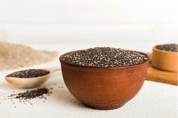 Chia seeds in bowl and spoon on colored background. Healthy Salvia hispanica in small bowl. Healthy superfood
