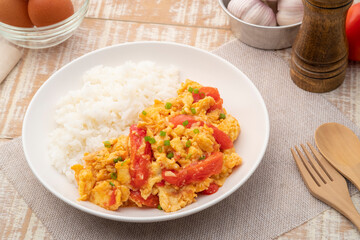 Stir fried egg with tomato,Scrambled eggs with tomatoes and cooked rice on white plate