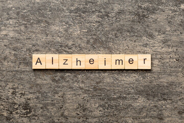 Alzheimer word written on wood block. Alzheimer text on cement table for your desing, concept