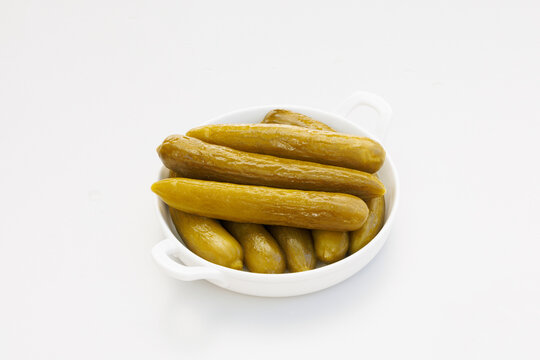 Pickles in dish on white background