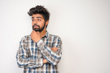 Fototapeta na wymiar young hispanic bearded man wearing plaid shirt over white background with positive expression, has broad interested smile. Look there, please.looking for something or found something