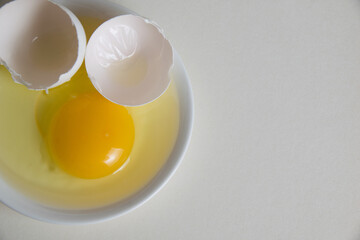 Egg yolk and shell on a plate isolate on a white background