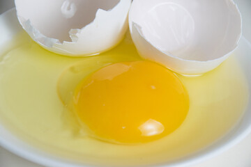 Egg yolk and shell on a plate isolate on a white background