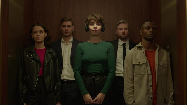 Elevator shot, female puts on headphones with her favorite music playing, light changes and separate her from the others