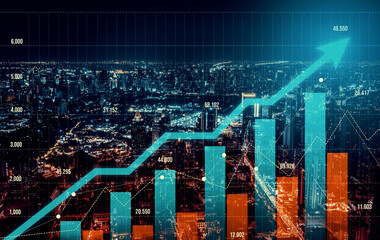 As background for a financial or business concept, digital screen and financial graphs overlap on a picture of modernistic cityscape, skyscrabbers.