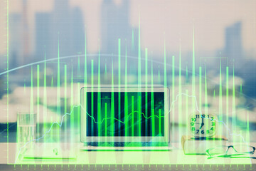 Stock market graph on background with desk and personal computer. Double exposure. Concept of financial analysis.