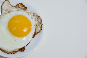 Fried egg on white plate and boiled egg in shell isolate on white background with space for text. Concept of high prices for eggs and food. Concept of healthy eating