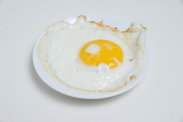 Fried egg on white plate isolate on white background flatlay top view