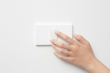 Woman hand pushing light switch at home, energy saving, copy space