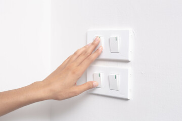 Female finger on and off the light switch at home, energy saving concept.