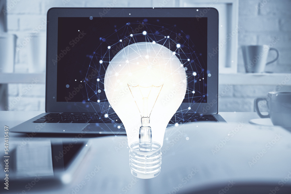 Poster Computer on desktop in office with bulb icon hologram. Multi exposure. Concept of idea.