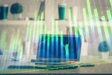 Stock market graph on background with desk and personal computer. Double exposure. Concept of financial analysis.