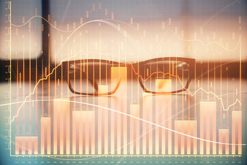 Financial graph hologram with glasses on the table background. Concept of business. Double exposure.