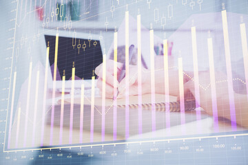 Financial graph displayed on woman's hand taking notes background. Concept of research. Multi exposure