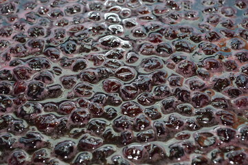 Cherry on a wooden spoon. The process of making jam. Harvesting sweet for the winter of fresh berries.