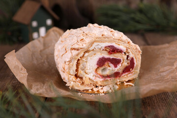 Meringue roll with strawberries on a wooden table