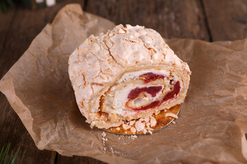 Meringue roll with strawberries on a wooden table