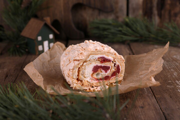 Meringue roll with strawberries on a wooden table