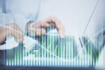 Double exposure of market chart with man working on computer on background. Concept of financial analysis.