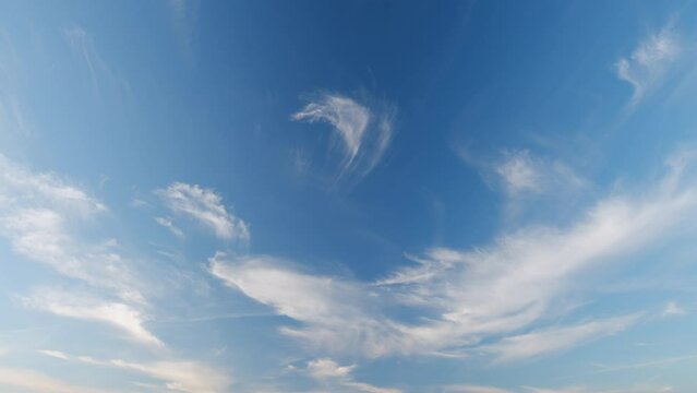 Cloud nature background. Blue sky with cirrus clouds and sun. Nature background of airy cloudscape. Timelapse.