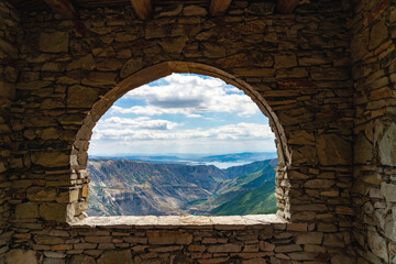 Breathtaking view from stone window of valley of Sulak canyon and reservoir surrounded by mountain ranges ahead