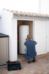 Man working on a domestic hot water tank