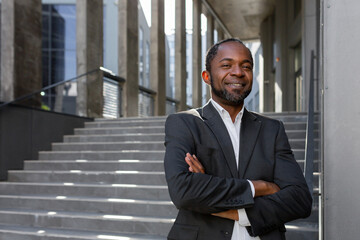 Portrait of successful african american businessman investor, mature boss with crossed arms smiling...
