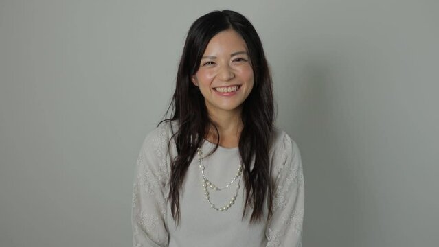 Asian beautiful woman smiles at the camera. Happy, Joy, Delighted. Dolly out.