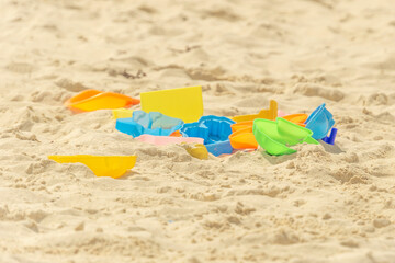 Fototapeta na wymiar Children's toys on the beach, colorful molds and paddles on the sand. Sandbox
