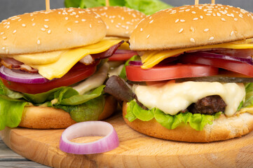 A toasted sesame bun hamburgers with pickles and ripe tomatoes